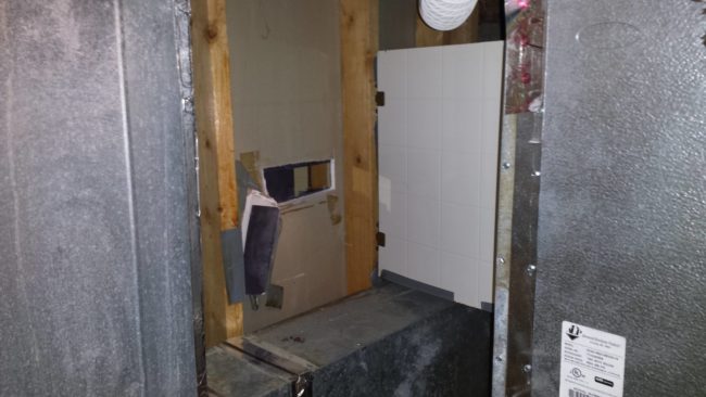 "Peephole into the bathroom found during renovations. Hinged panel covering holes cut into 2-way mirror."