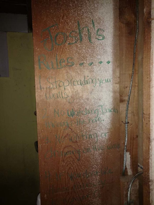 Here's a clearer image of what they saw: "Josh's Rules. Stop reading your walls. No watching Isaiah through the hole. No writing or drawing on the walls."