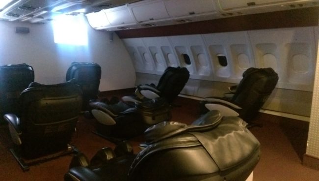 The plane-themed room is filled with seats that are also massage chairs. For your entertainment, they always have a movie going.